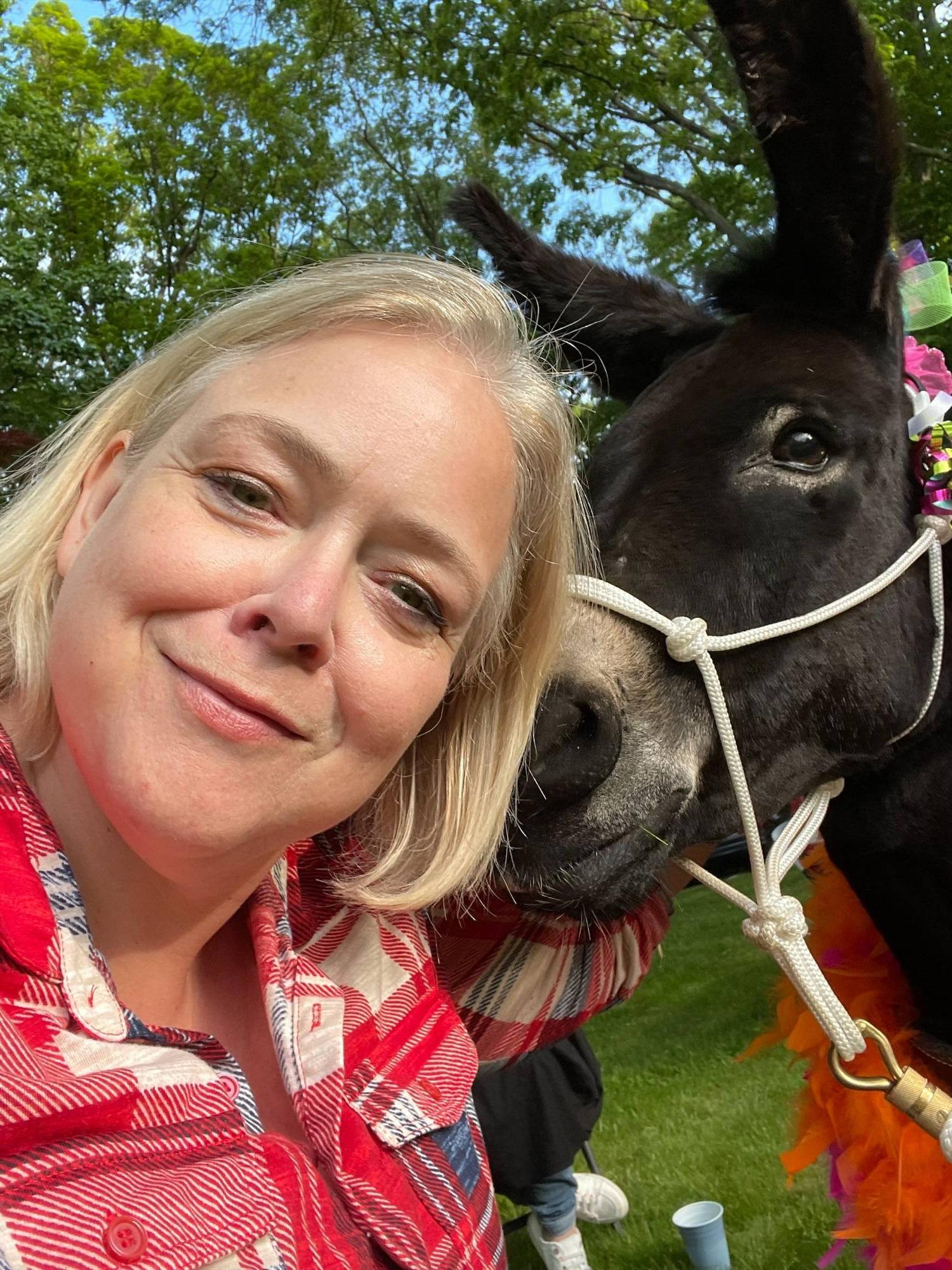 Fran Cain standing in front of a donkey